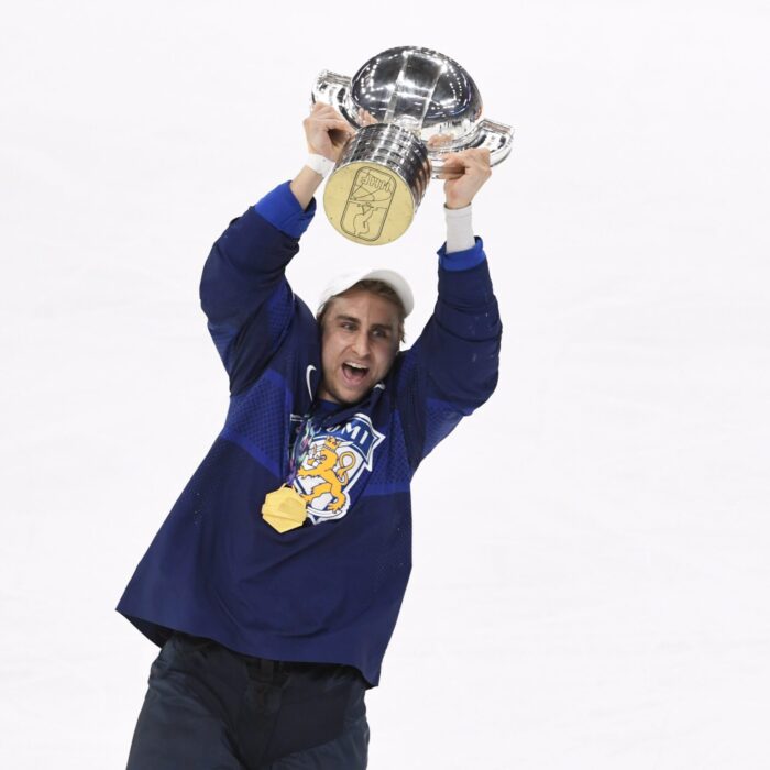 An ice-hockey player lifting a trophy cup.