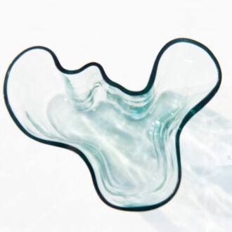 A light-blue decorative glass bowl sits on a white surface.