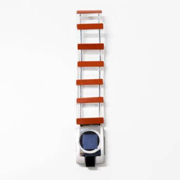 A wearable wristband made of clear sections and red bars connected to a square gadget with a digital screen.