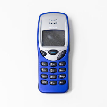 A compact blue mobile phone featuring a small display and raised number buttons placed on a white background.