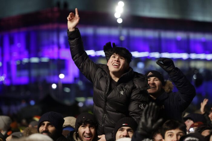 Boys celebrating in a huge crowd in the evening light of Helsinki