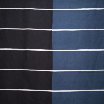 Der „Tibet“-Stoff von Vuokko Eskolin-Nurmesniemi zeigt abwechselnd schwarze und blaue Felder, die von gleichmäßig verteilten weißen horizontalen Linien durchzogen sind.