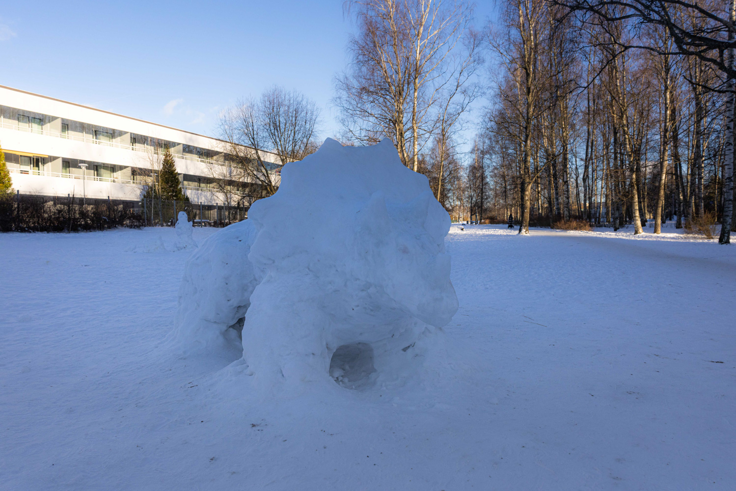 A snow sculpture of a dinosaur stands in the yard of an apartment building in the Helsinki neighbourhood of Lauttasaari.
