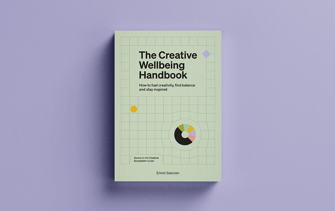 صورة لكتاب The Creative Wellbeing Handbook للمصمّمة الفنلندية إيمّي سالونن، تظهر فيه مربعات ومخطط دائري بألوان متعددة.