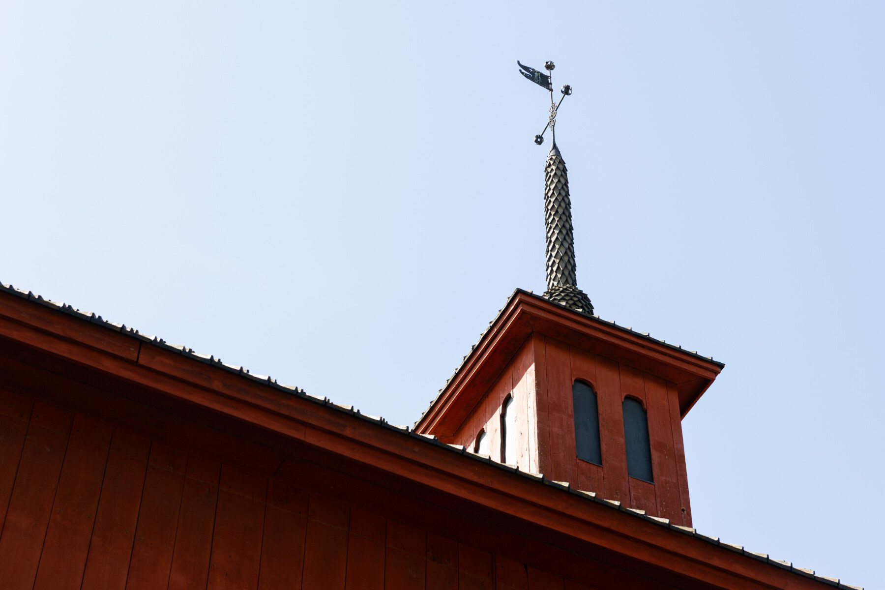 A weathervane rises above the red wooden tower of the Pedagogio schoolhouse in Kokkola’s Neristan district.