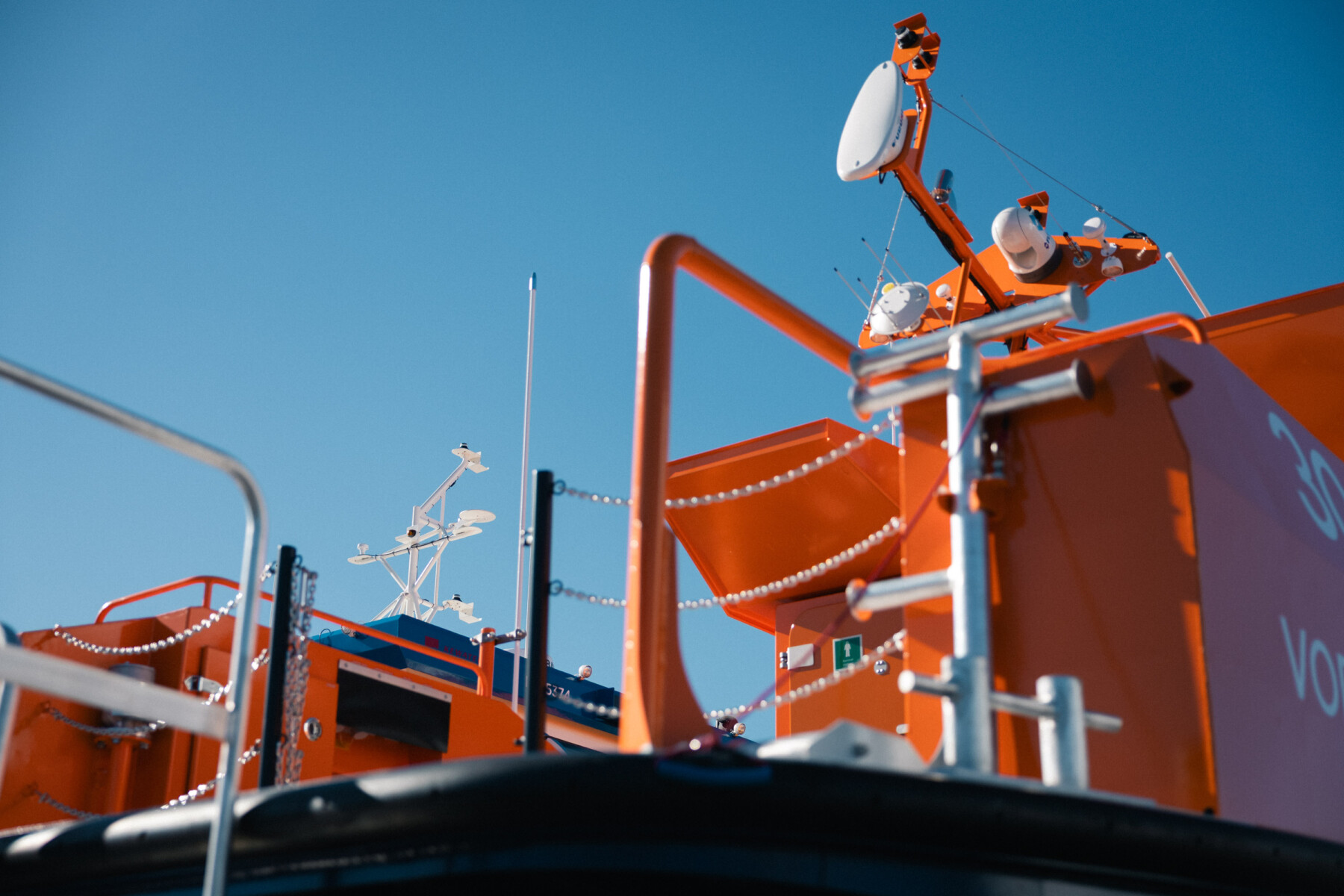 Antennen und Ausrüstung ragen über das Deck eines orangefarbenen Arbeitsboots, das vom finnischen Bootshersteller Kewatec gebaut wurde.