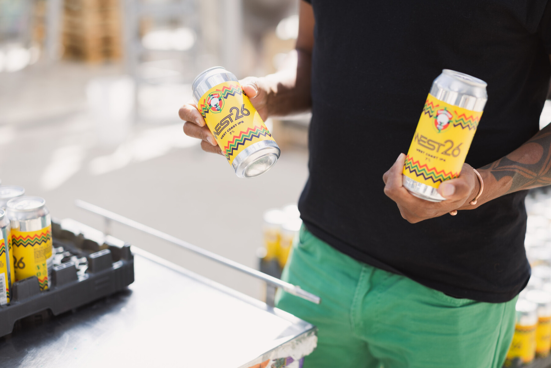 CoolHead founder Cleber Gonçalves displays bright yellow cans of the brewery’s beer during the packaging process.