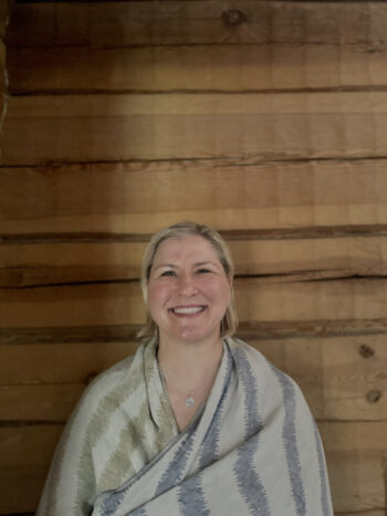 A woman (Katja Pantzar) smiles at the camera while wrapped in a towel.
