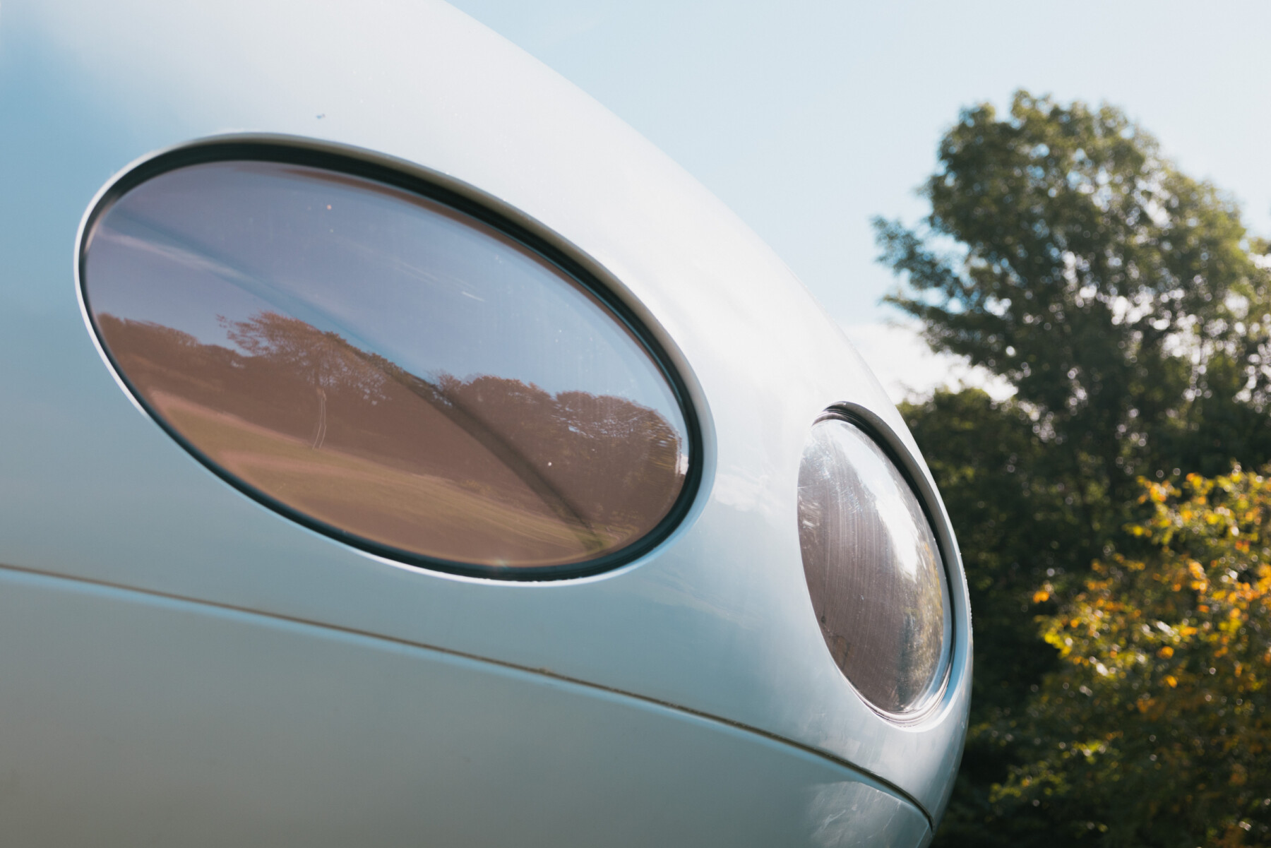 Two rounded windows punctuate the curved shell of the Futuro, reflecting trees and the surrounding grounds in their tinted acrylic plastic.